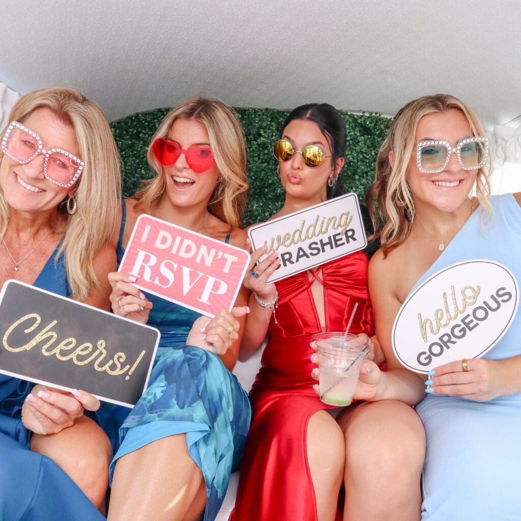 Wedding guests, smiling at the camera, while inside of Penny the Photo Bus, at a Tampa, Florida Wedding.