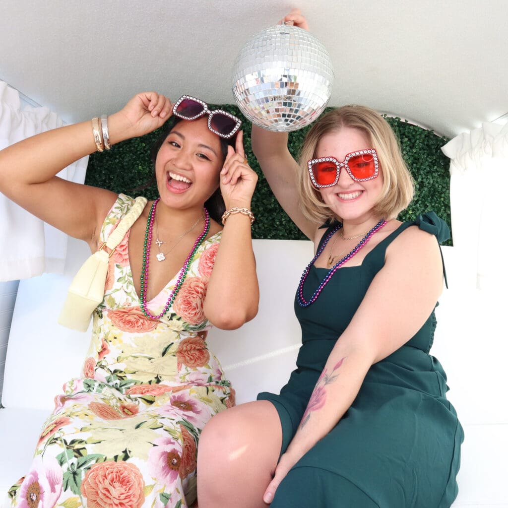 Two women smiling at the camera inside of Penny the Photo Bus, in Sarasota, Florida